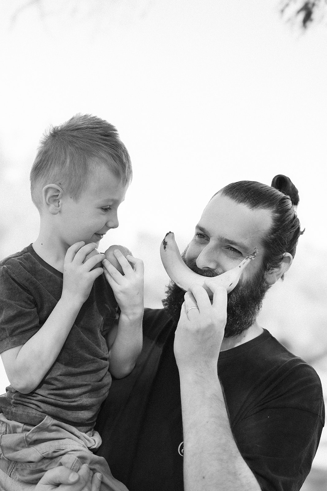 Father son smiling holding fruit