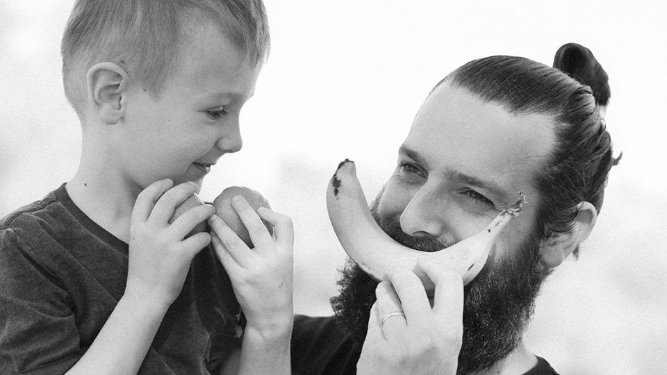 Father son smiling holding fruit